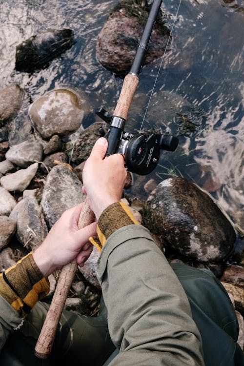 Free Person Holding Black and Brown Fishing Rod Stock Photo