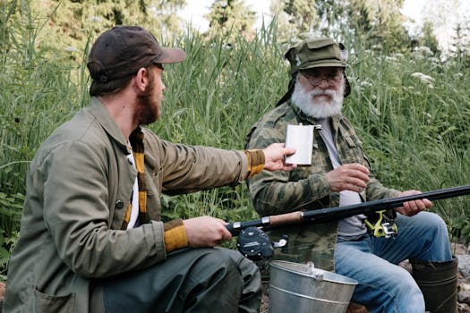 Two men fishing together in a lush countryside, sharing a moment by the riverbank.