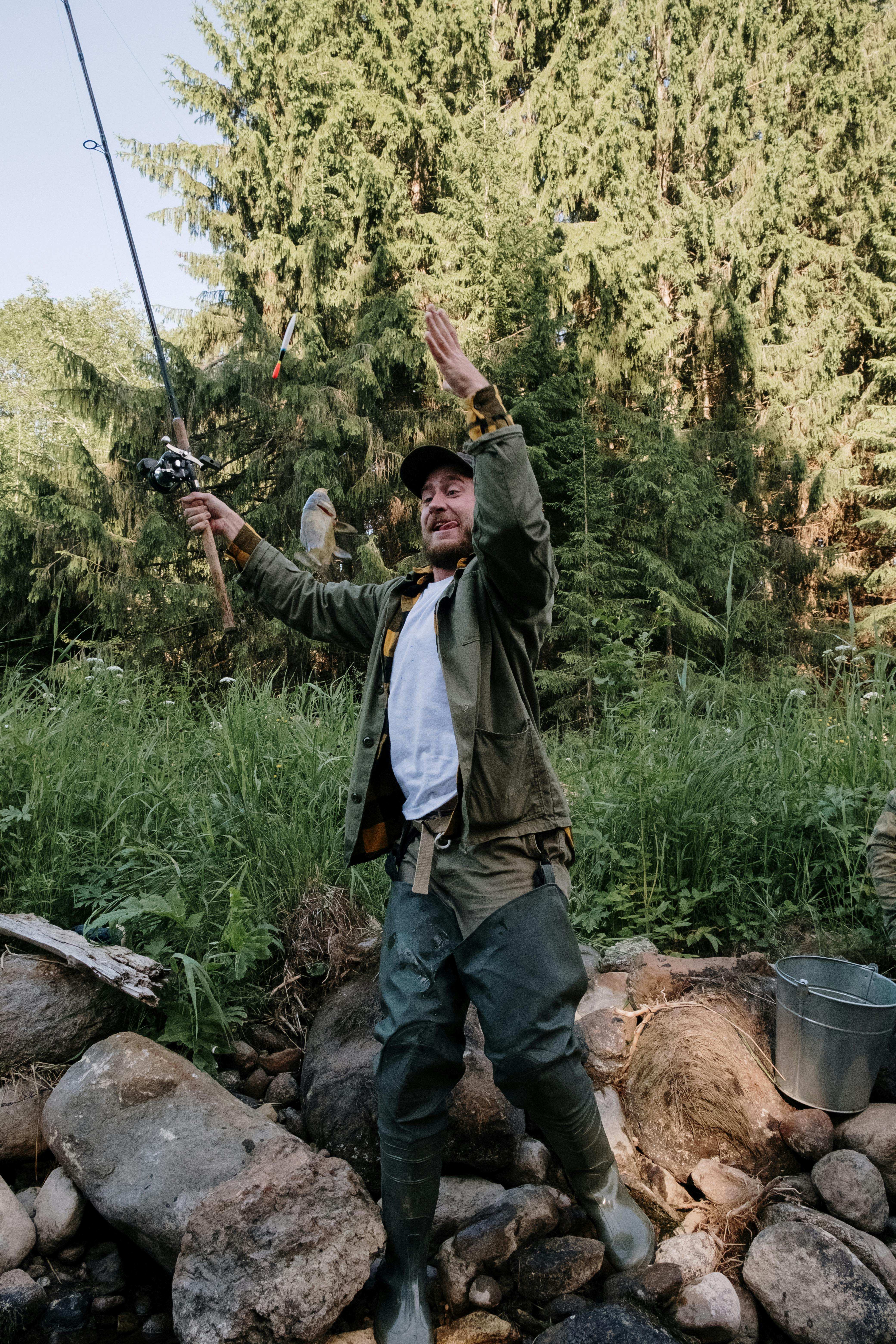 Man in Gray Jacket Holding a Fishing Rod · Free Stock Photo