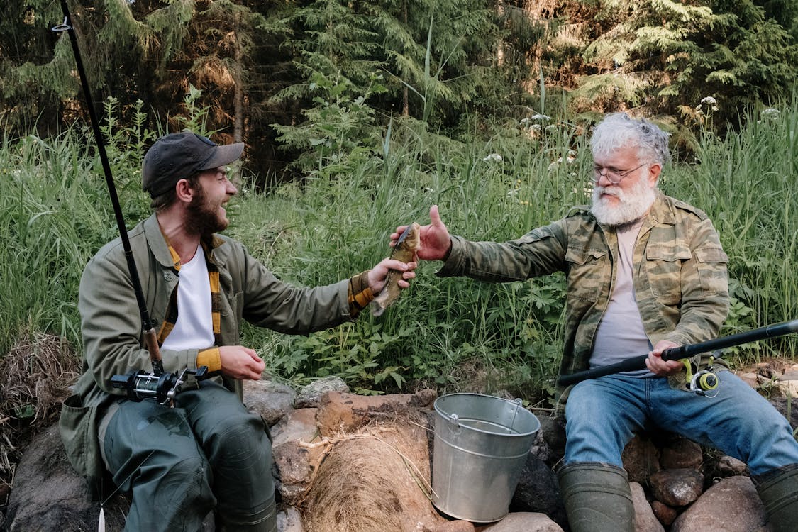 Free Man in Green Jacket Holding a Man in Green Jacket Stock Photo