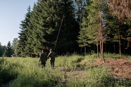 2 Men Walking on Green Grass Field