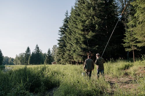 2 Men Walking on Green Grass Field