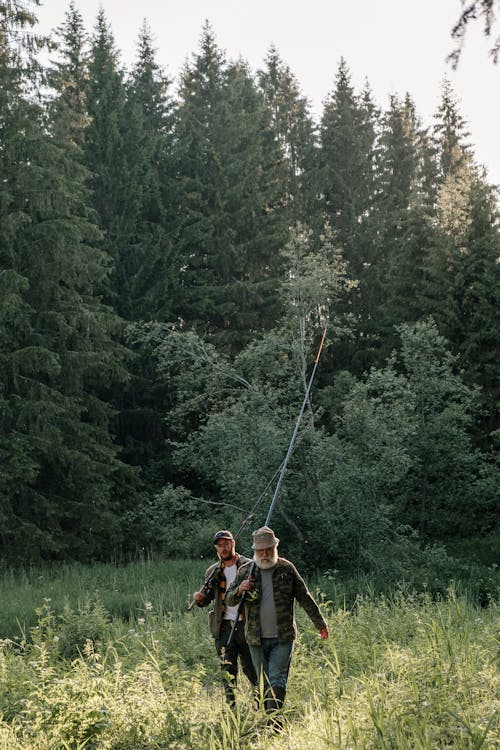 Man and Woman Walking on Green Grass Field