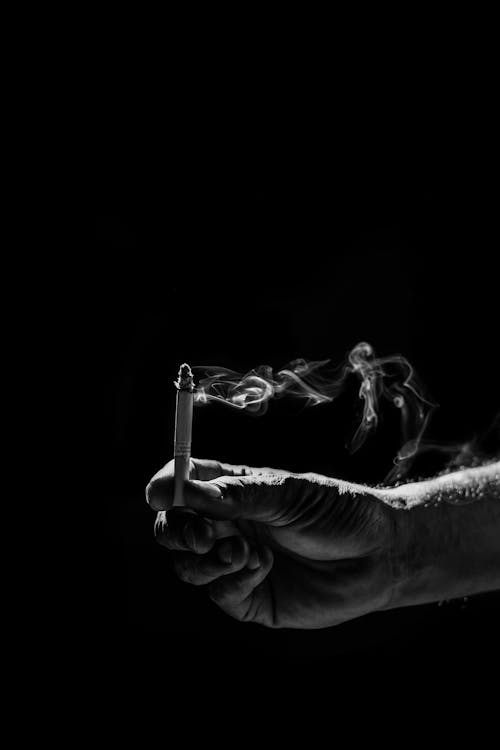 Foto stok gratis tentang asap, background hitam, grayscale, hitam & putih,  memegang, monokrom, puntung rokok, rokok, tangan, tembakan vertikal, wallpaper  hitam