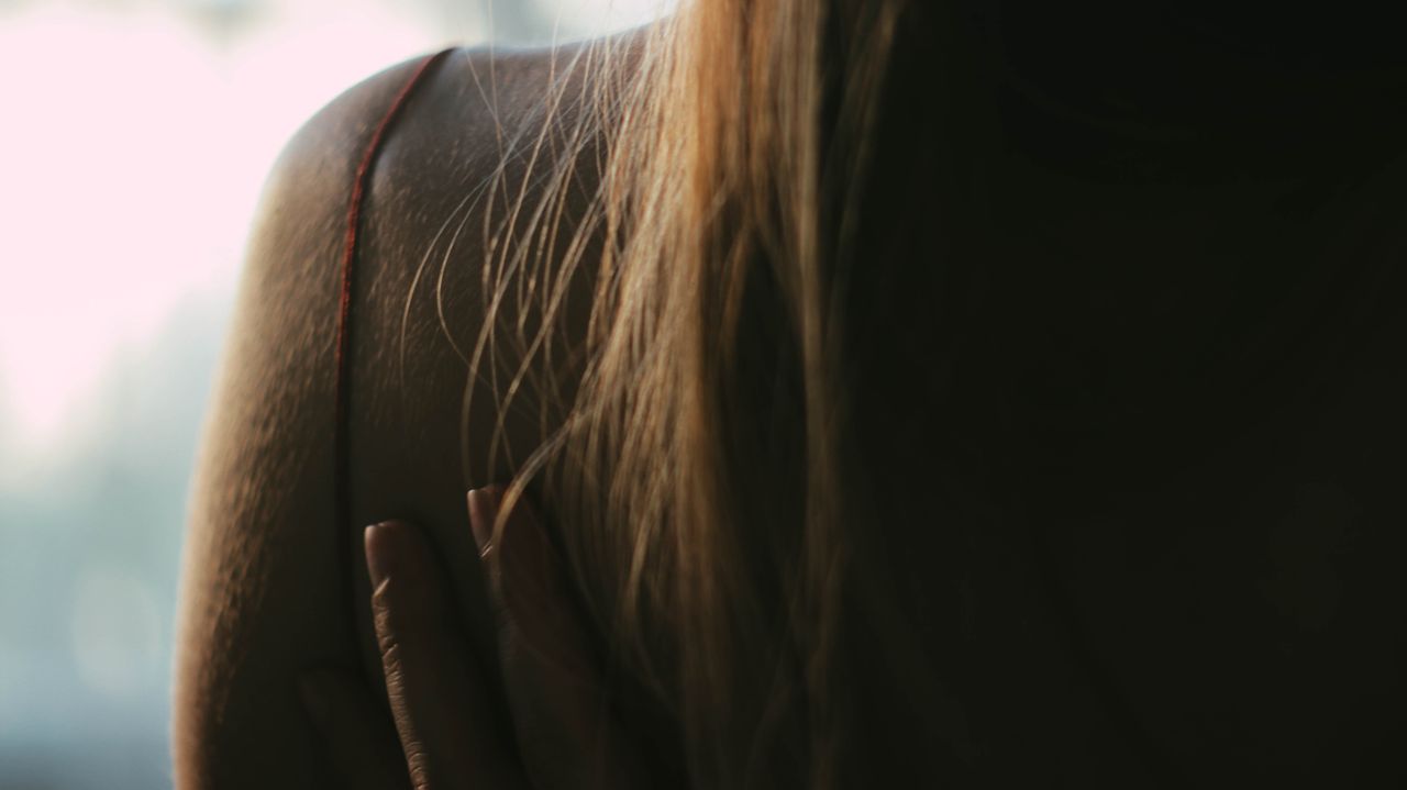 back view of anonymous female with blond hair wearing cloth with thin