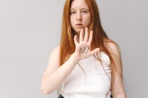 Woman calmly holding up a hand, setting a boundary with confidence