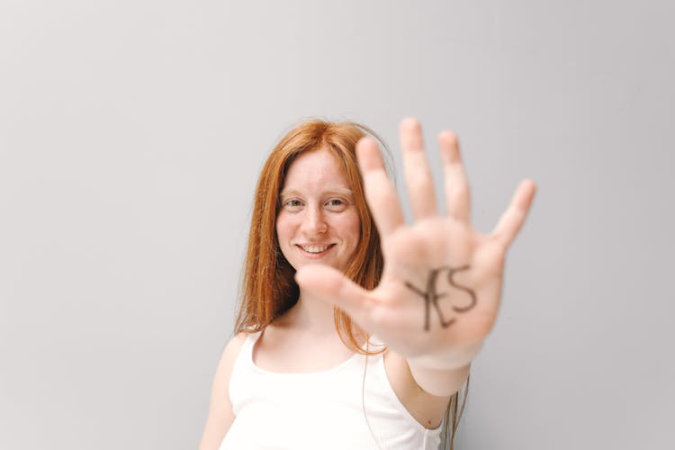 A Woman Showing The Word Yes On Her Palm