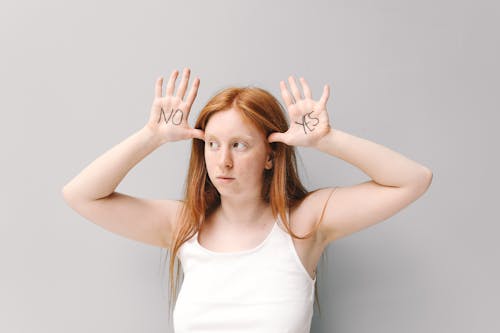 A Woman in White Tank Top with Yes and No Written on Her Palms
