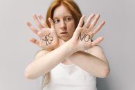 Woman in White Shirt Covering Her Face With Her Hands