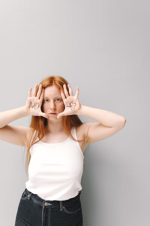 Free Woman in White Tank Top with Her Hands on Her Face Stock Photo