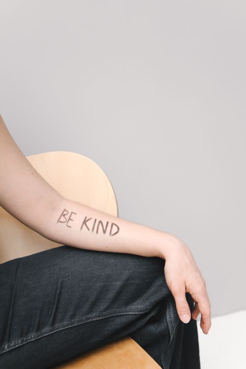 Free A close-up of a forearm with 'Be Kind' written on it, promoting kindness. Stock Photo