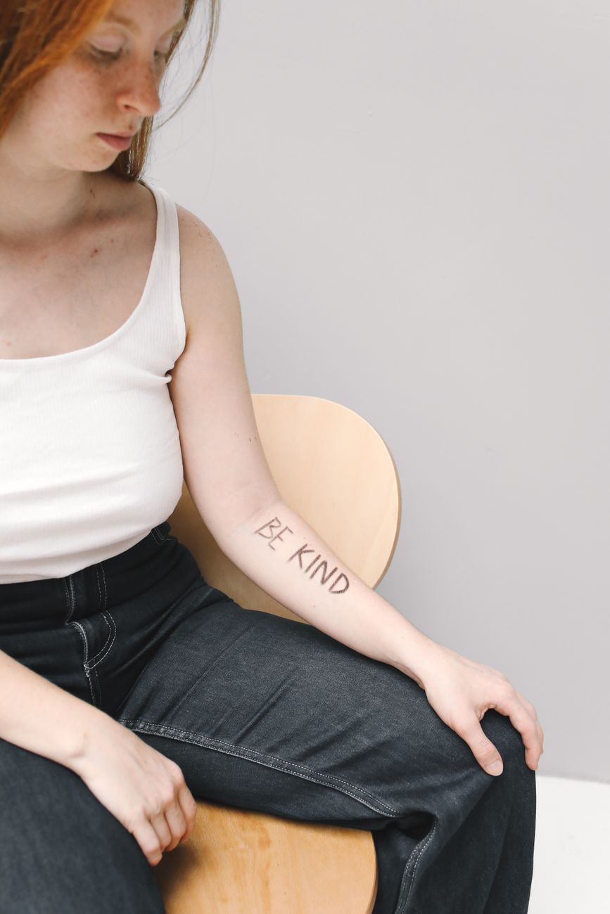 Woman wearing a delicate script temporary tattoo on her forearm in everyday wear