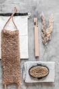 Top view composition representing zero waste bath products including bamboo toothbrush body brush and bast wisp arranged on gray marble surface