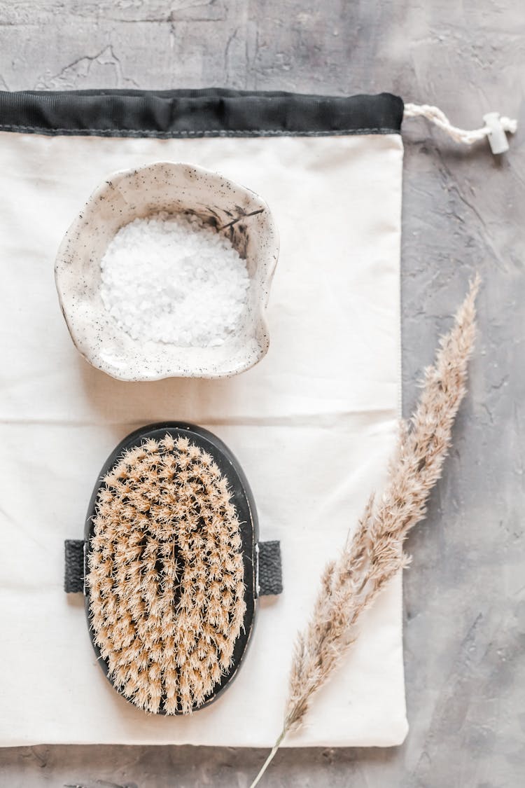 Body Brush And Bath Salt Placed On Marble Table