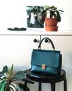 Stylish handbag on stool in light room