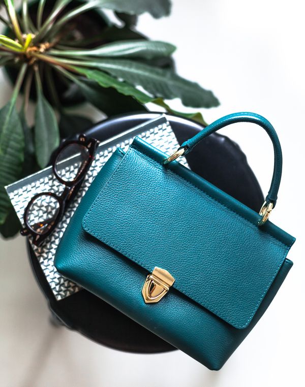 Dark blue handbag placed on a stool — photo by Diana Light on Pexels