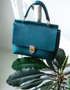 Trendy leather purse hanging on chair back post