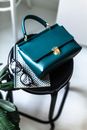 Fashionable leather purse placed on stool