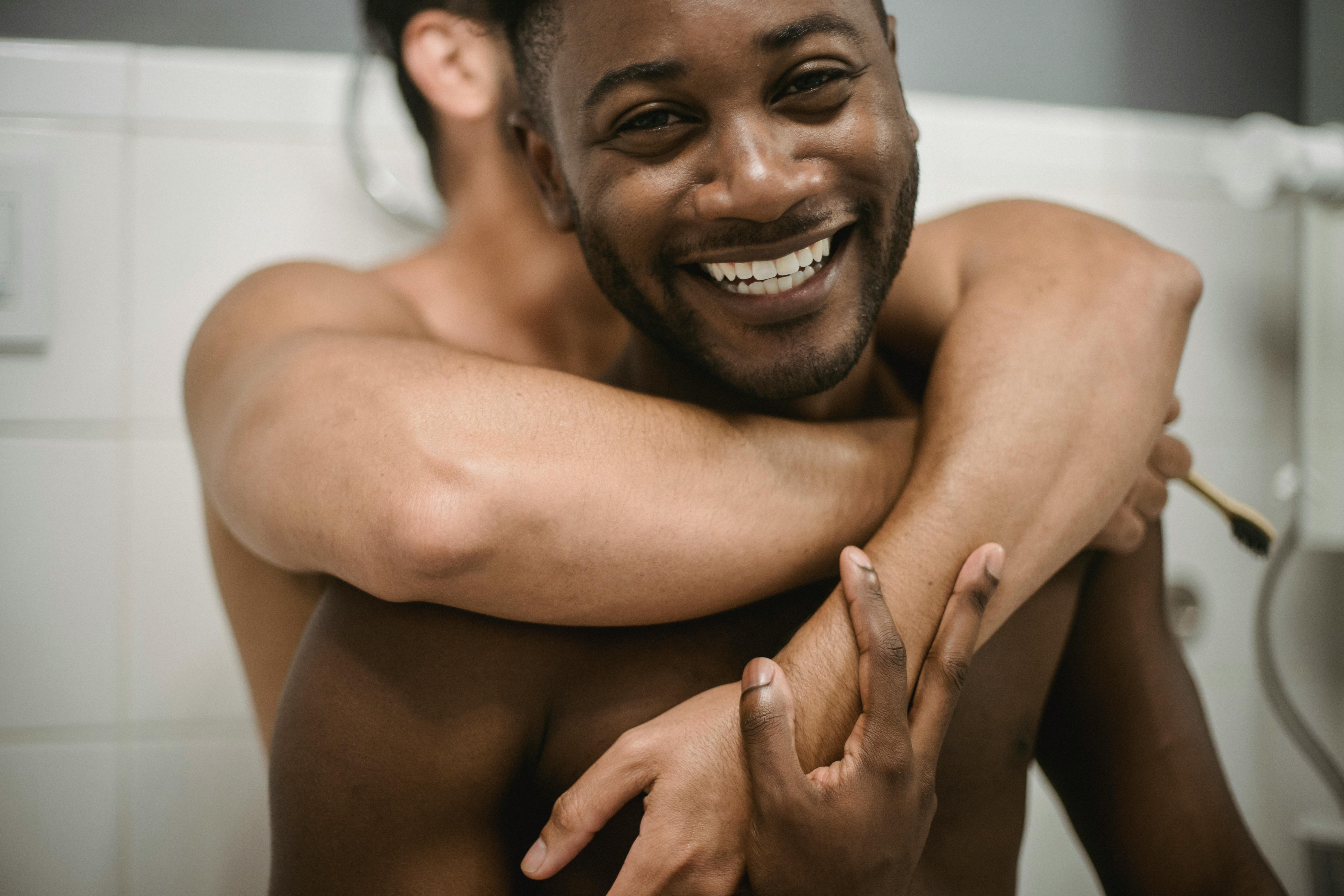 topless men smiling and hugging