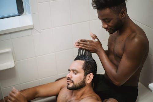 Free Man Washing Another Man's Hair Stock Photo