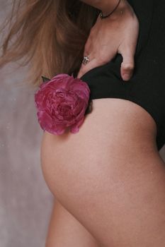 一位身着黑色泳衣、头戴粉色花朵的女子，展现优雅的艺术照片