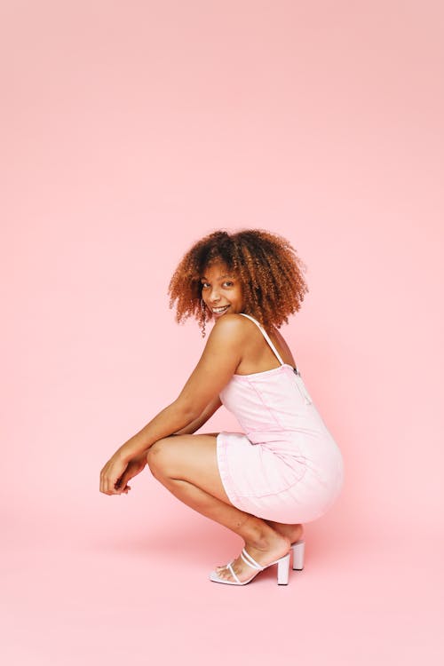 Photo of a Girl in a Pink Dress Crouching