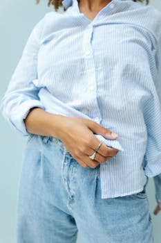 Close-up of a woman wearing denim jeans and a striped shirt, showcasing casual fashion style.