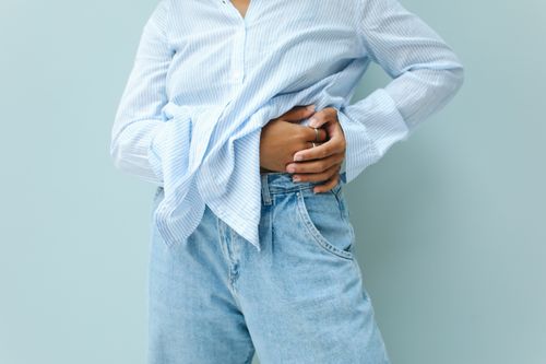 Free A person in a blue striped shirt and jeans, posing fashionably against a neutral background. Stock Photo