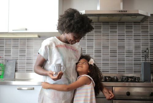 Mother and Daughter Hugging in a Kitchen