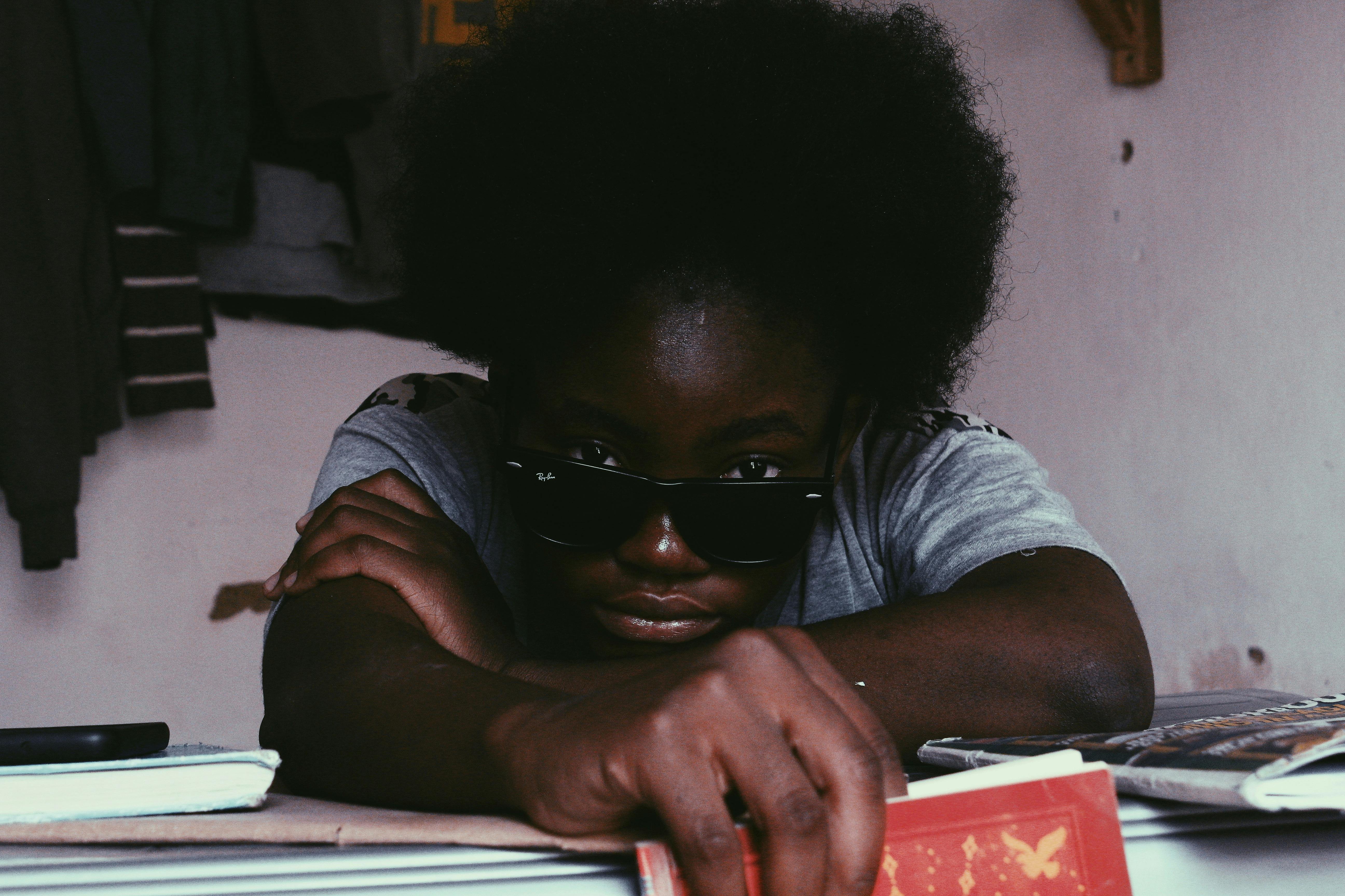 black woman in sunglasses lying on hands and looking at camera