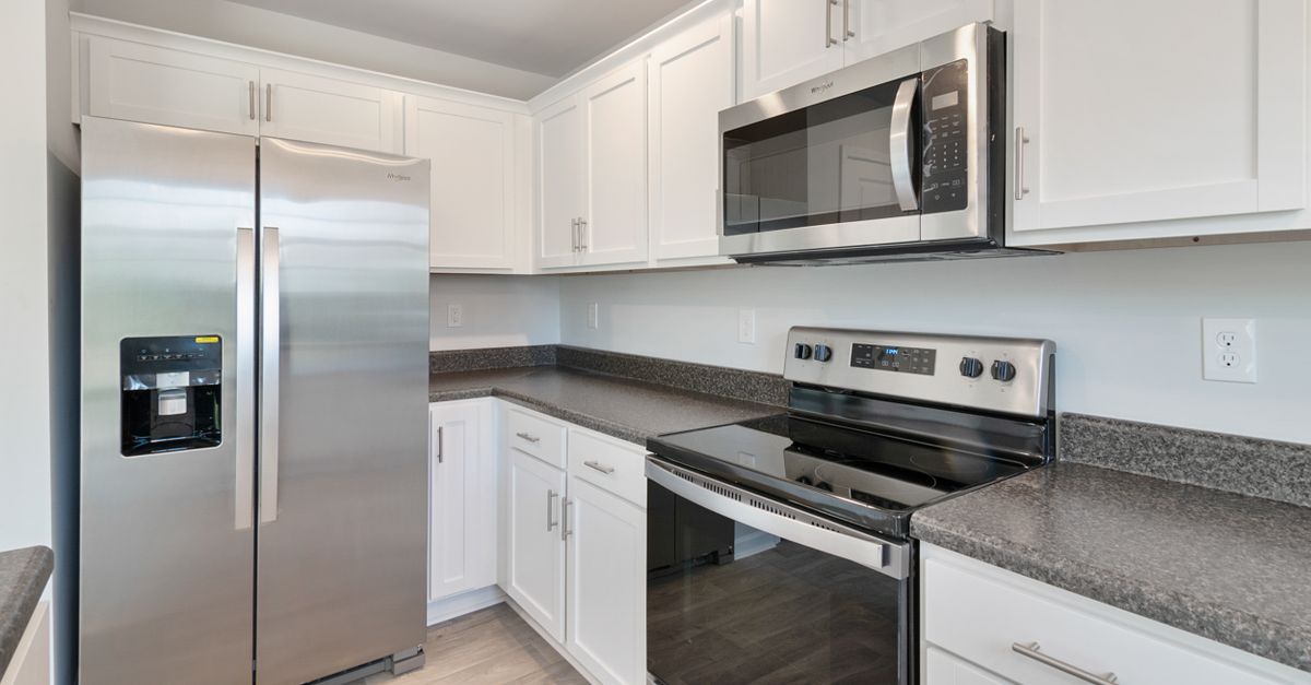 Sleek kitchen with stainless steel appliances and white cabinetry.