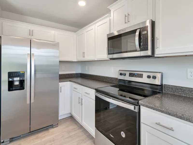 Sleek kitchen with steel appliances and white cabinetry Sleek kitchen with steel appliances and white cabinetry