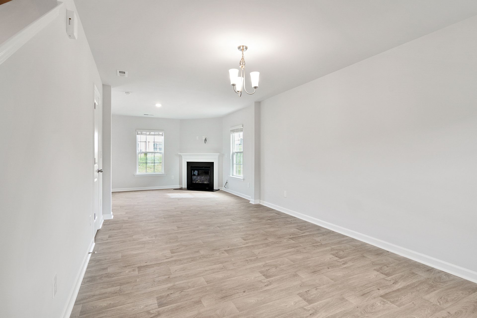 Spacious refurbished living room with white walls and natural light.