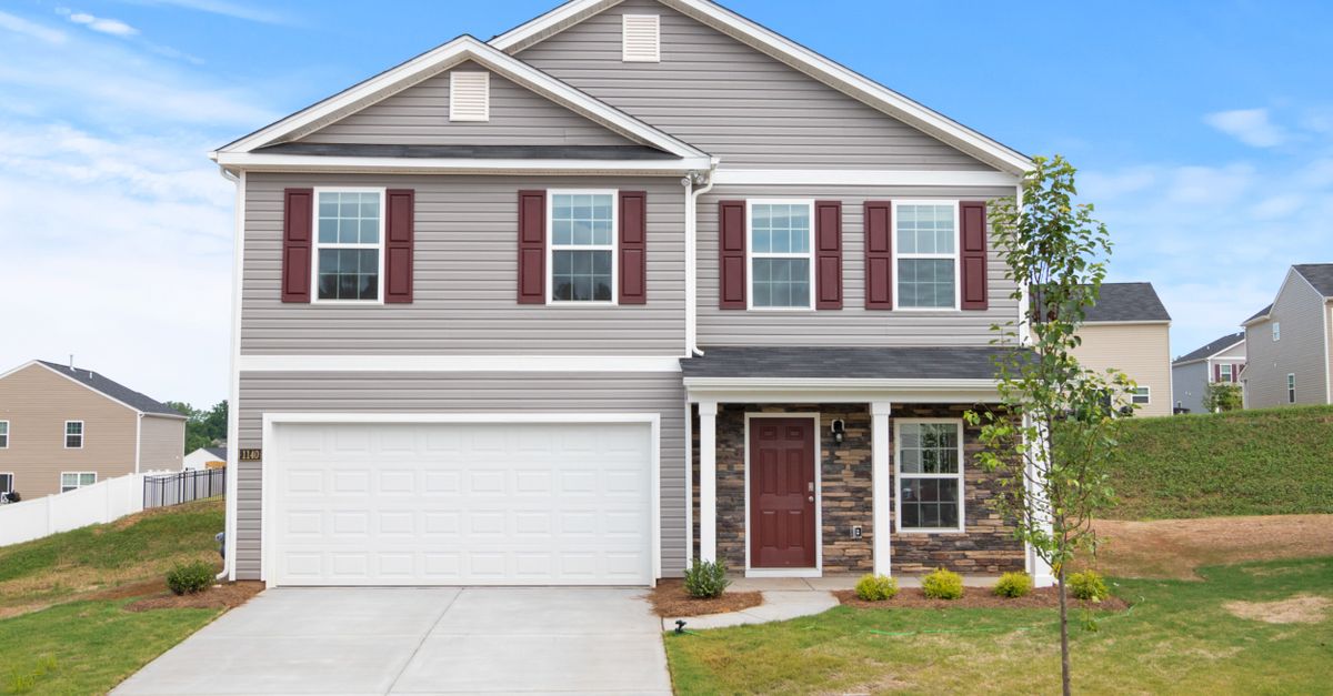 A modern suburban house with a neatly landscaped front yard and driveway.