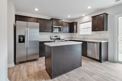 Free Sleek modern kitchen design featuring stainless steel appliances and dark wood cabinetry. Stock Photo