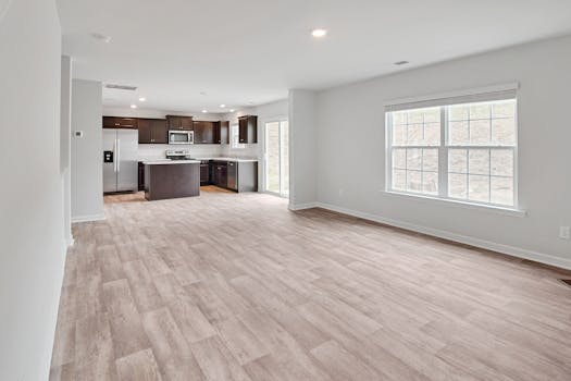 Bright open floor plan featuring a modern kitchen and spacious living area with parquet flooring.