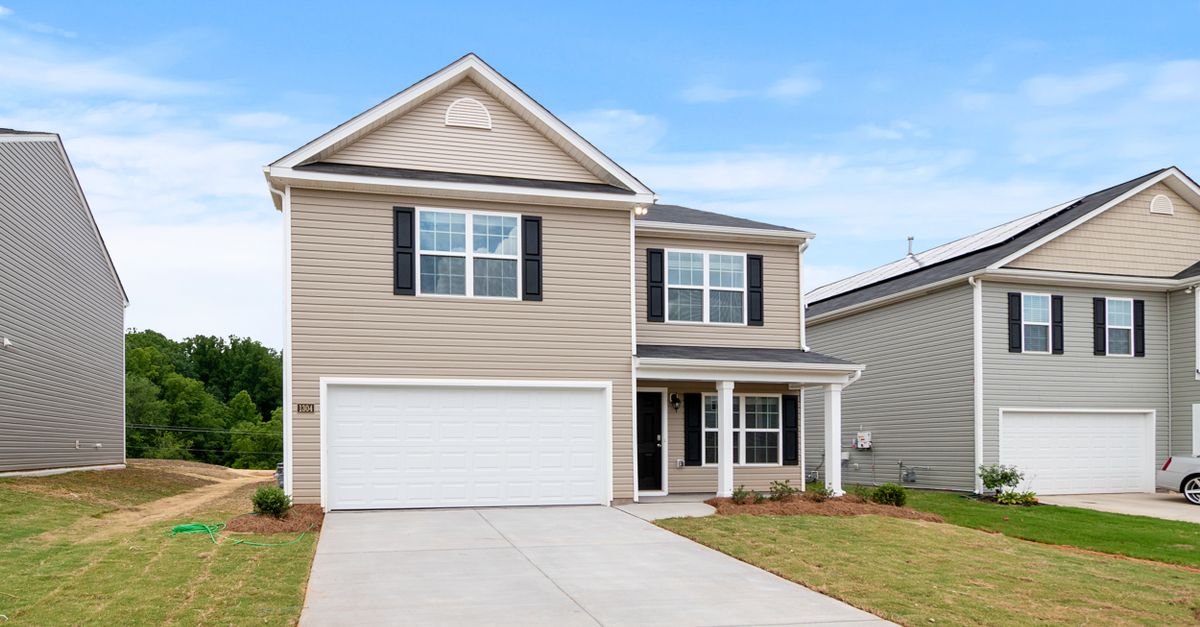 Contemporary two-story suburban home with a spacious driveway and lawn.