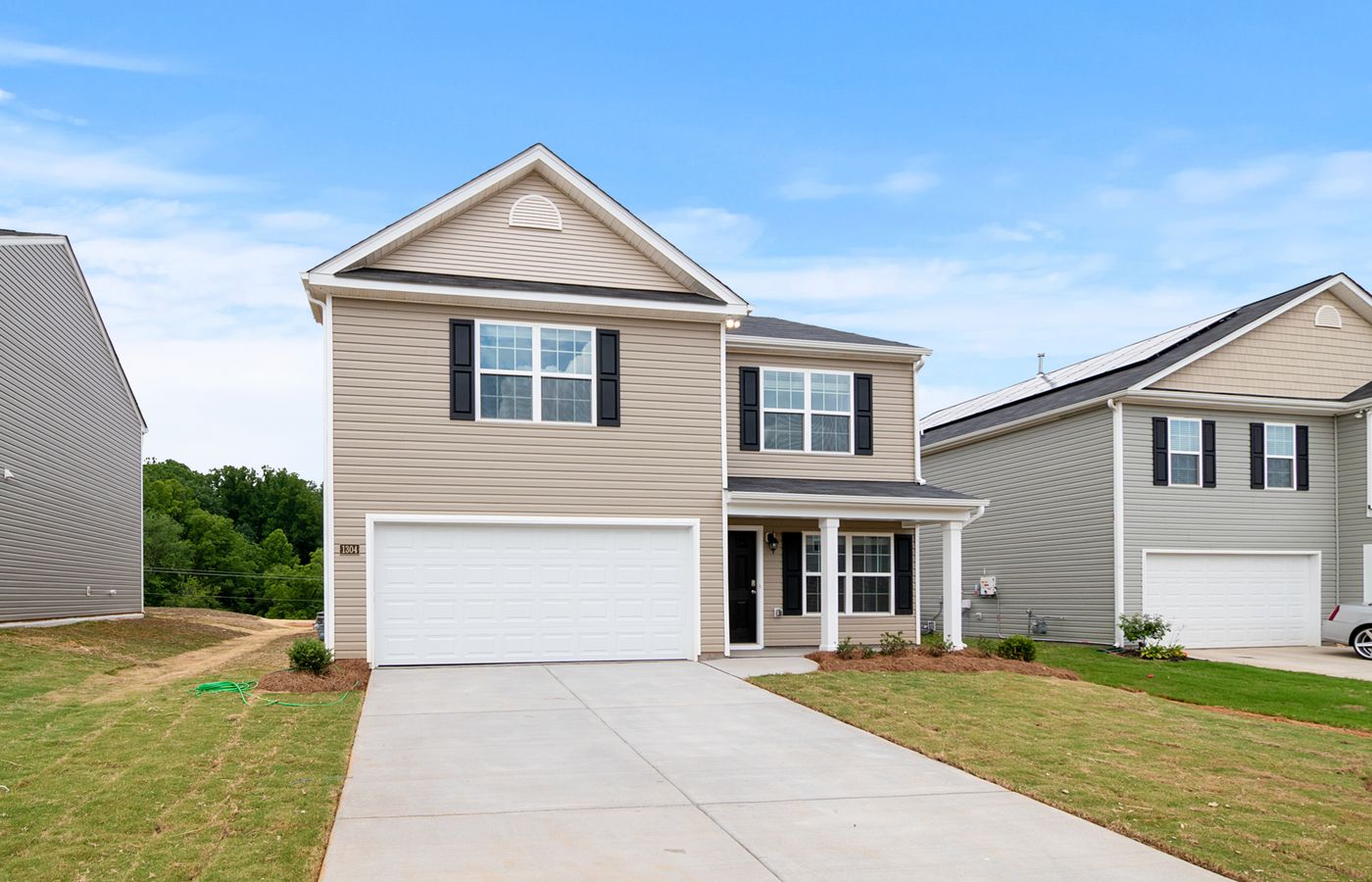 Contemporary two-story suburban home with a spacious driveway and lawn.