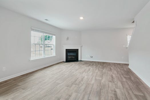 Bright and spacious living room featuring a modern fireplace and parquet flooring, ideal for contemporary interiors.