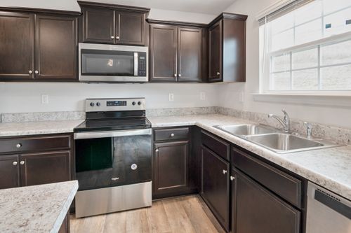 Free Sleek kitchen interior featuring dark wood cabinets, stainless steel appliances, and ample counter space. Stock Photo