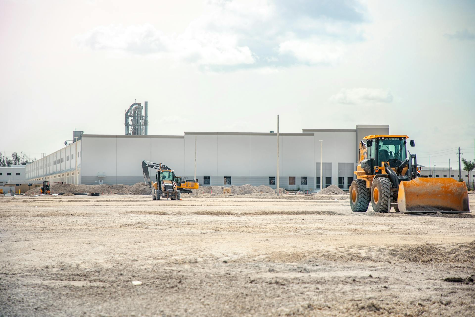 A large construction site featuring heavy machinery and industrial building in progress.