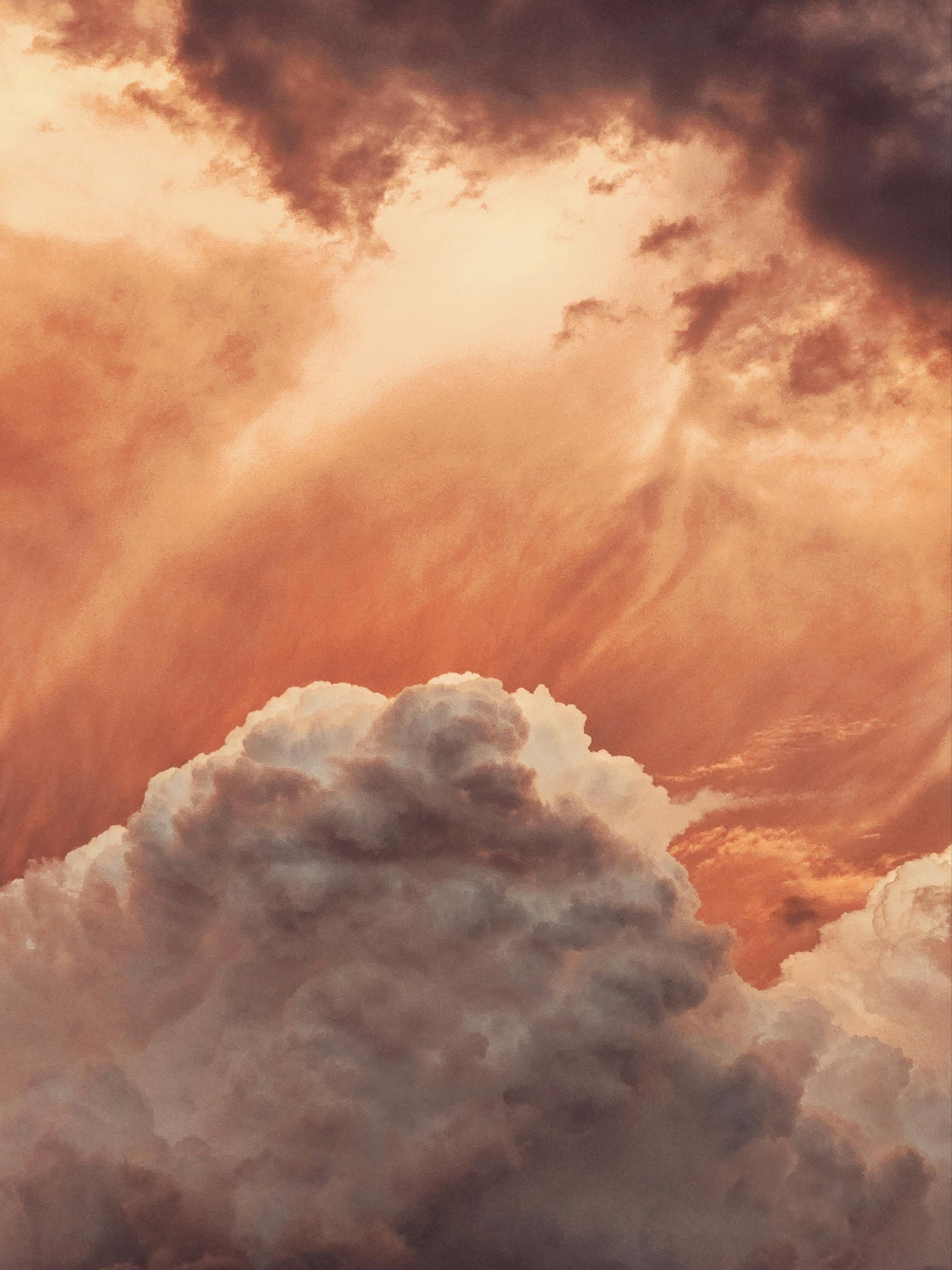 Bright sunlight floating in fluffy many orange and white huge clouds in daytime in summer