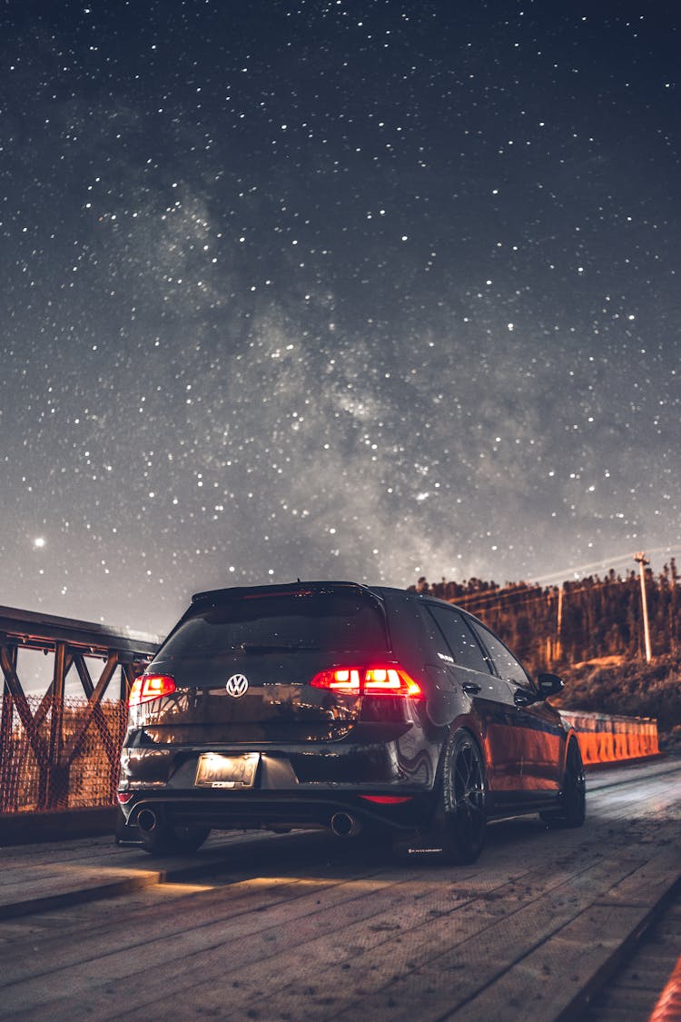 Contemporary Crossover Car Parked On Bridge Against Starry Sky At Winter Night