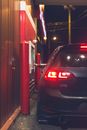 Unrecognizable person sitting in modern car and making purchases in drive through at night
