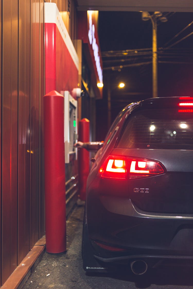 Anonymous Person Buying Products From Drive Thru In Evening