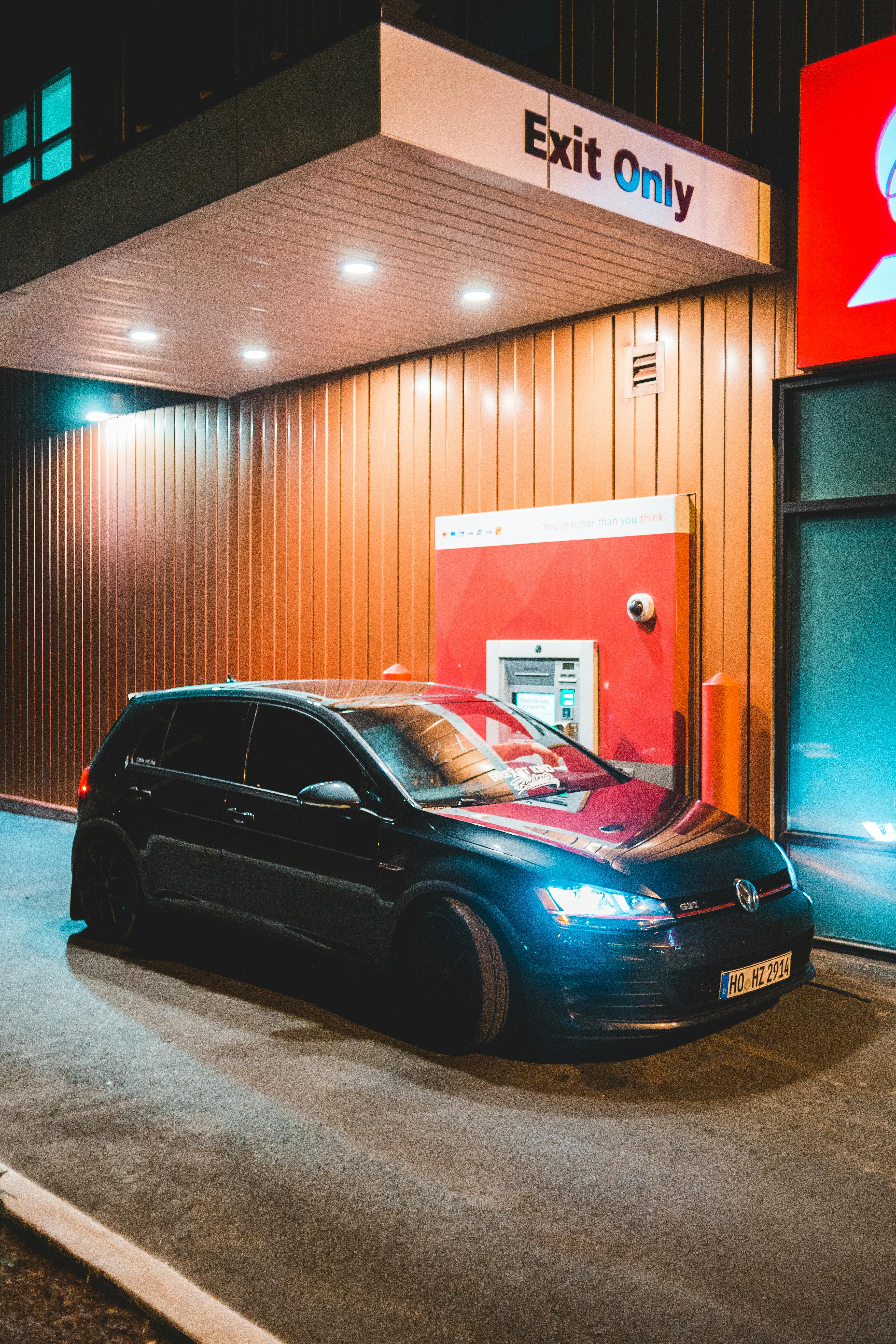 Contemporary Car Parked Near Drive Thru At Night · Free Stock Photo