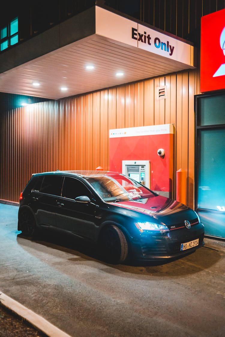 Contemporary Car Parked Near Drive Thru At Night