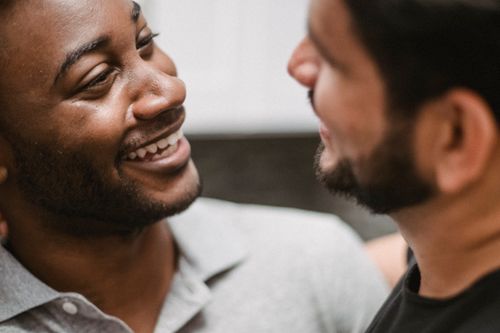 Free A candid close-up of two men smiling at each other indoors, capturing genuine happiness. Stock Photo