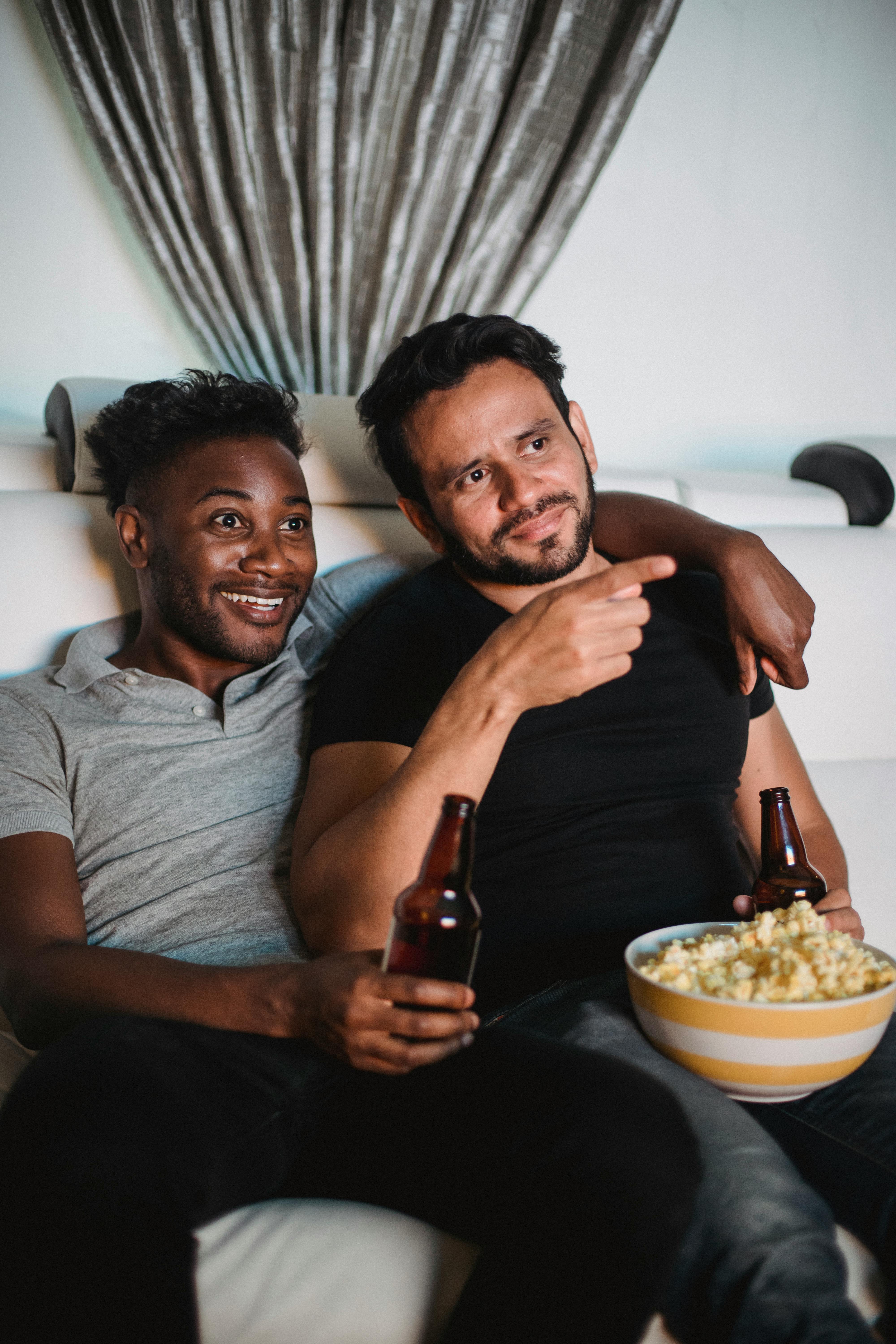 couple watching a movie drinking beer and eating popcorn