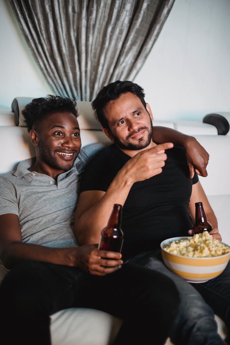 Couple Watching A Movie, Drinking Beer And Eating Popcorn 